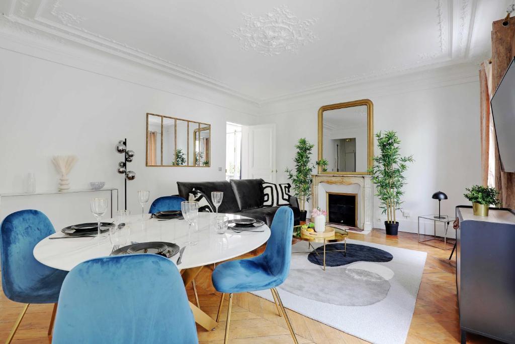 un salon avec une table et des chaises bleues dans l'établissement Magnificent apartment - 1BR-4P - Parc Monceau, à Paris