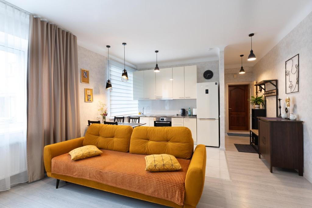 un soggiorno con divano giallo e una cucina di Centra apartamenti Elīza a Limbaži