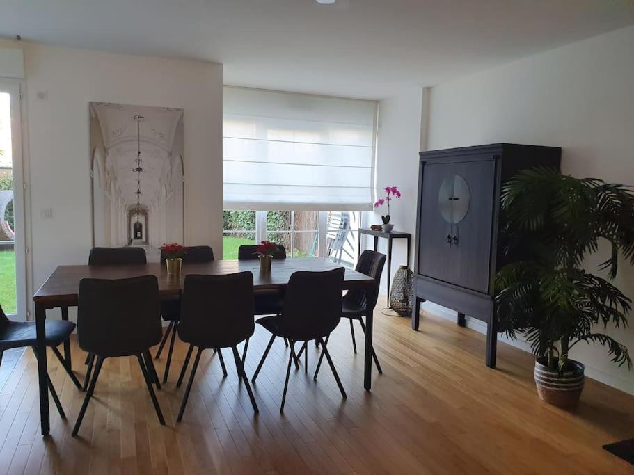 a living room with a dining room table and chairs at Garden Alley House 8 personnes in Serris