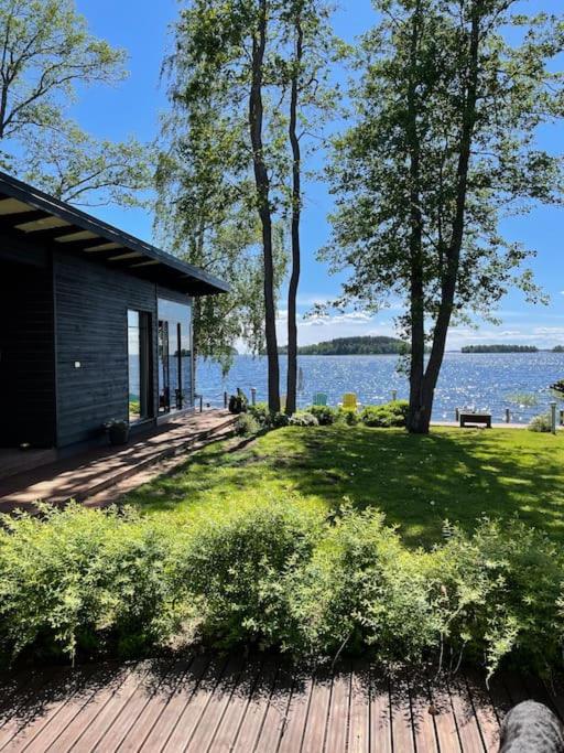 a house on a deck with a view of the water at Moderni rantasauna ja -mökki in Joensuu