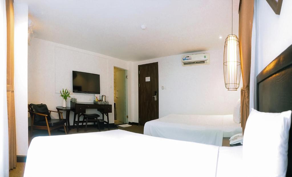 Postel nebo postele na pokoji v ubytování Rosa Hanoi Hotel