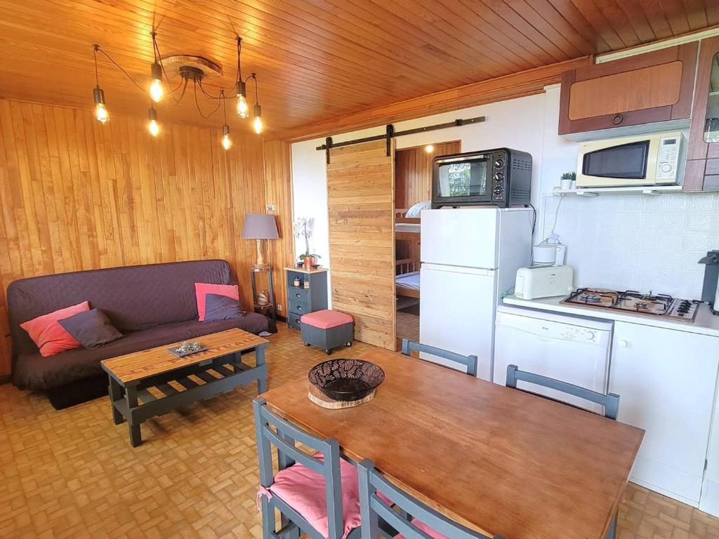 a kitchen and a living room with a couch and a table at Appartement au RDC d'un Chalet - Proche Ski/Randonnées - Terrasse Sud - 4 pers - FR-1-393-150 in Saint-Michel-de-Chaillol