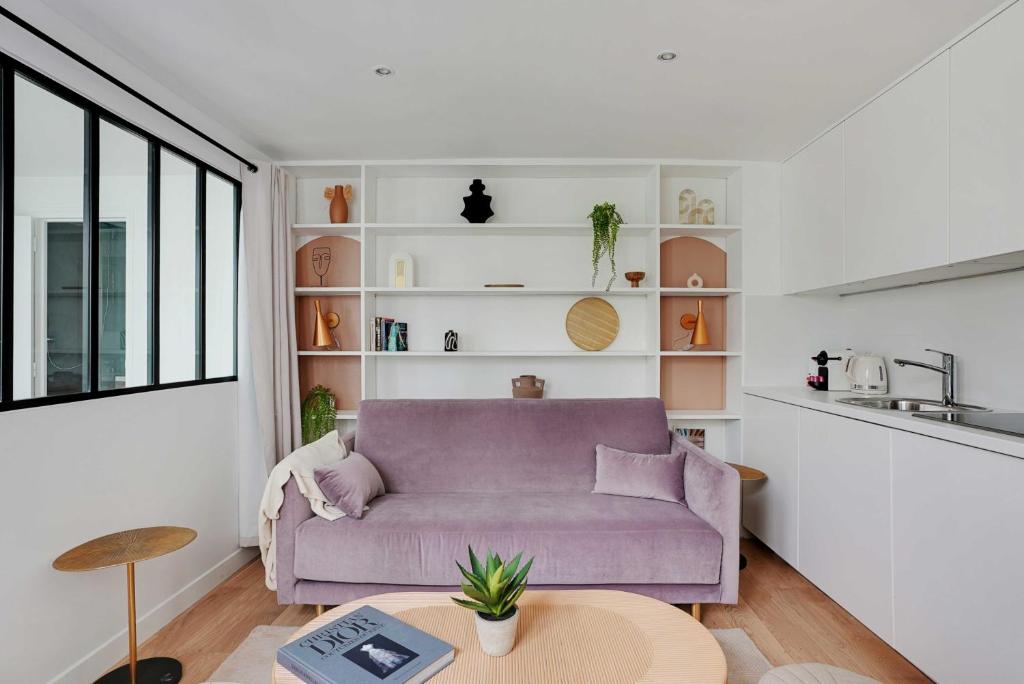 un salon avec un canapé violet et une table dans l'établissement Magnificent apartment - 1BR-4P - Palais Royal, à Paris