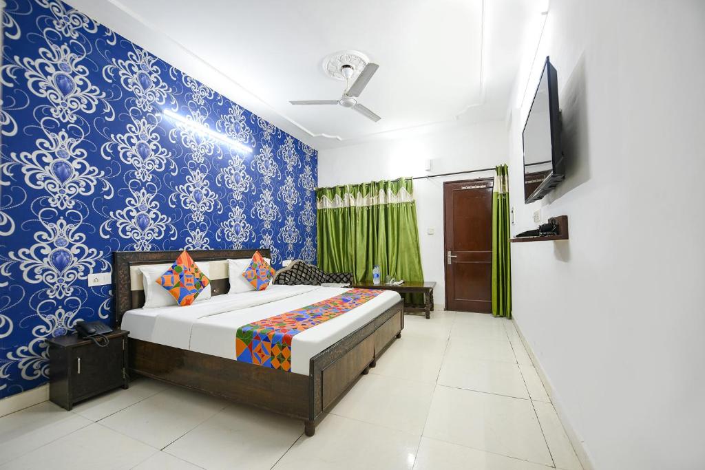 a bedroom with a bed and a blue wall at FabExpress Diamond Sec 45 in Chandīgarh