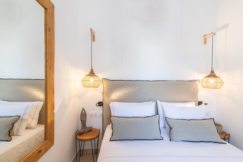 een slaapkamer met twee bedden en een spiegel bij Anemis in Tinos Town