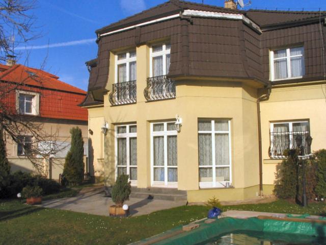 una casa con piscina frente a ella en Villa Olivia, en Praga