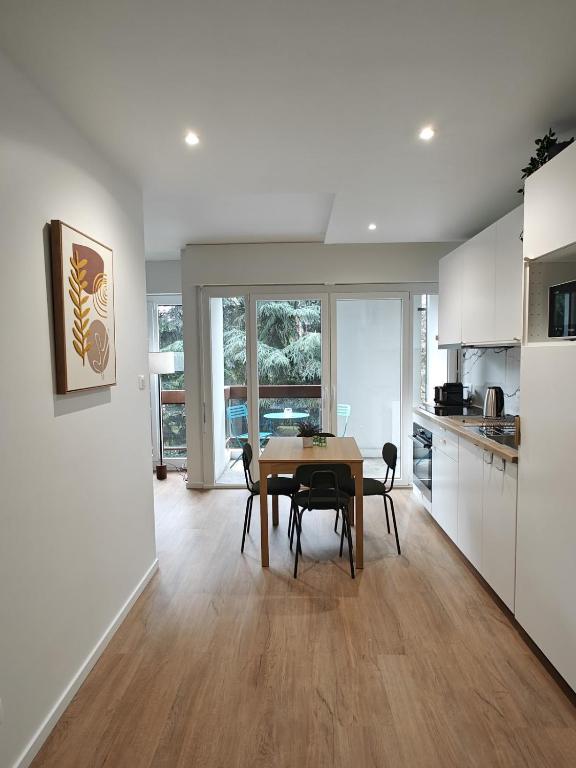une cuisine et une salle à manger avec une table et des chaises dans l'établissement Les Glières - Appartement confortable et au calme, à Annecy