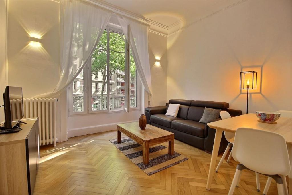 un salon avec un canapé et une table dans l'établissement Agastaïa - Monthly Rental Apartment - Lyon 7th, à Lyon