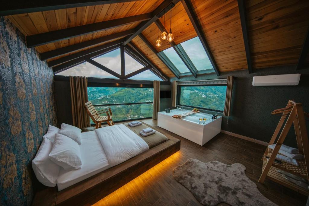 a bedroom with a bed and a tub in a room at Lazivilla Suit Dağ Evi in Rize