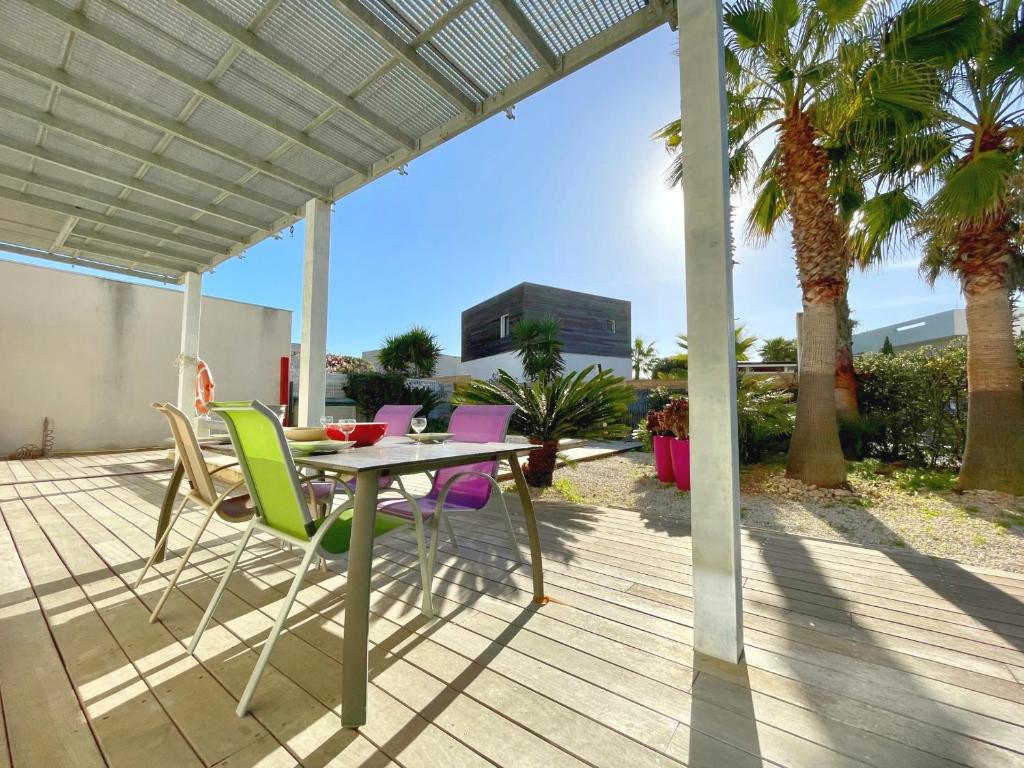 un patio avec une table et des chaises sur une terrasse dans l'établissement Villa Moderne à Sète: Piscine Privée, Plage à 200m, Clim, WIFI - FR-1-338-334, à Sète