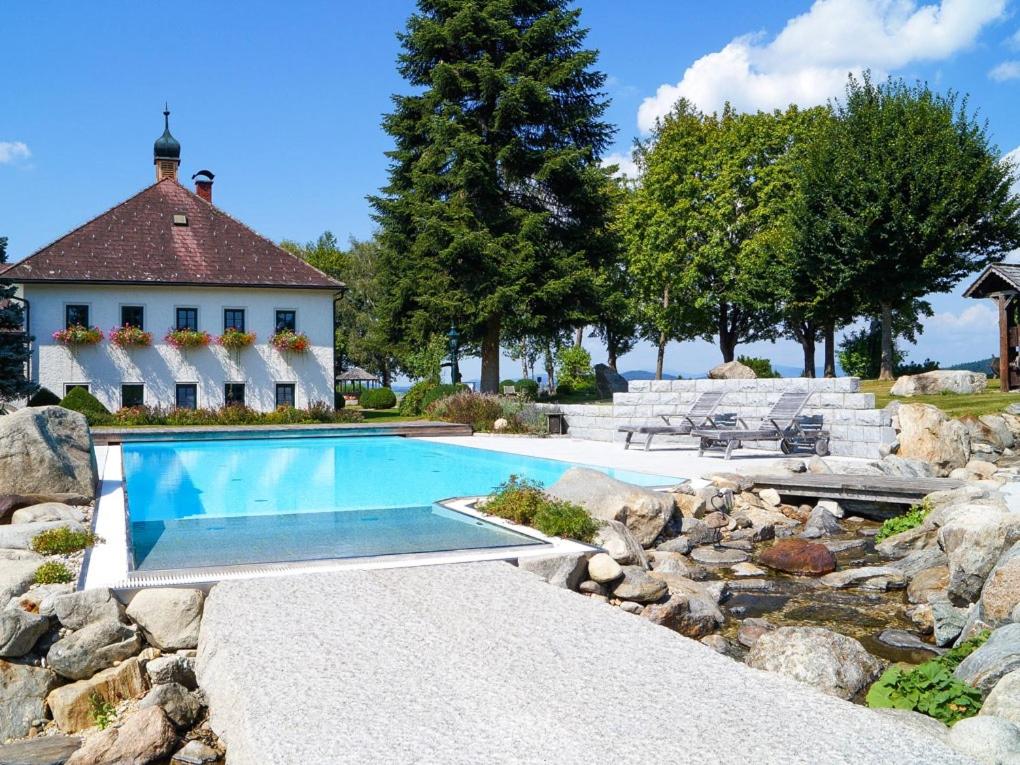 a swimming pool in front of a house with a rocky yard at Room in a Farm Residence Austria - Shared bathroom in Iglbach