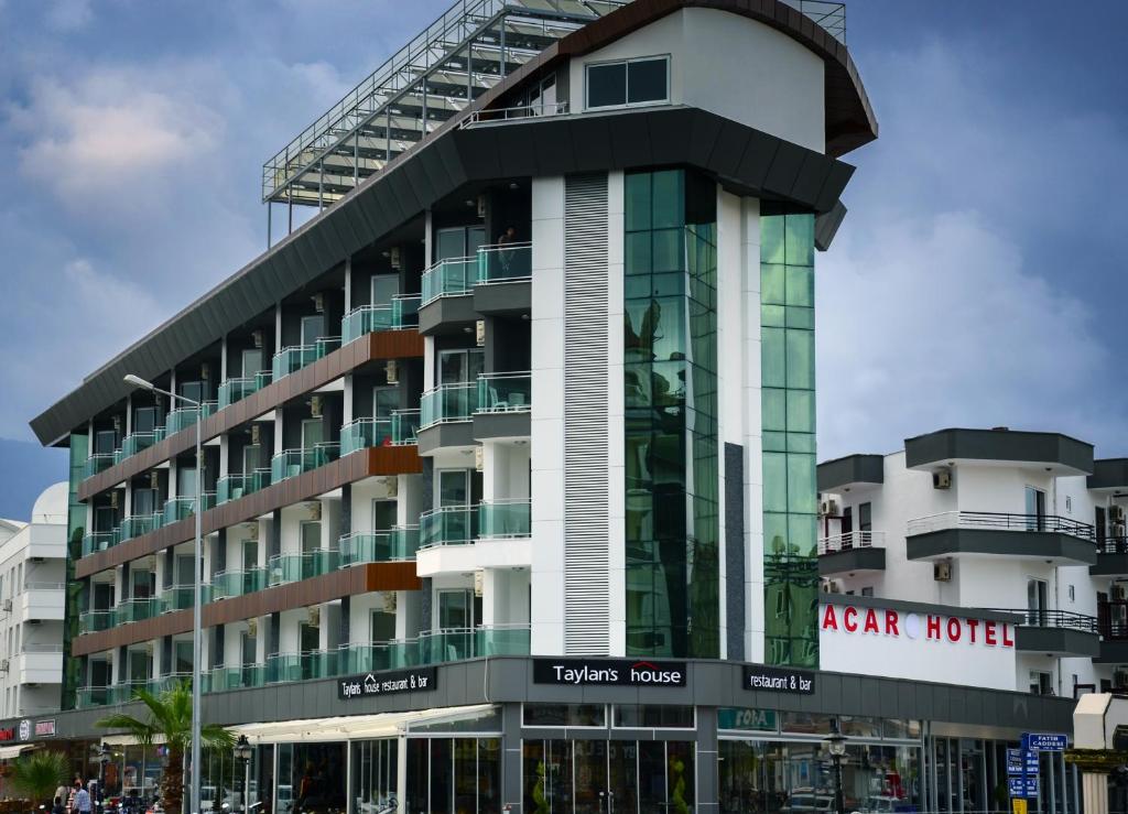 a hotel building with a glass facade at Acar Hotel in Alanya