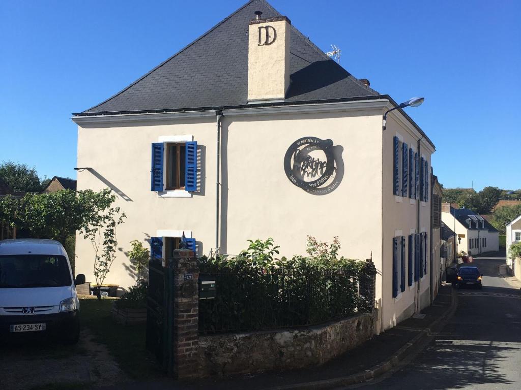 ein weißes Gebäude mit einer Uhr an der Seite in der Unterkunft Appartement 40m² lumineux avec cuisine équipée, Wi-Fi gratuit, proche mairie et église à Fay - FR-1-410-301 in Fay