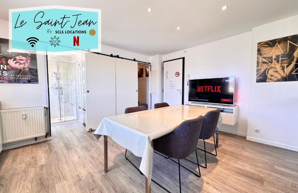 une salle à manger avec une table et des chaises et une télévision dans l'établissement Le Saint-Jean By SCLS Locations, à Cannes