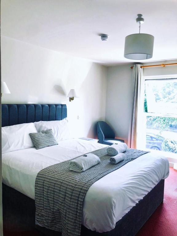 a bedroom with a bed with two towels on it at The Vines Hotel in Alvescot