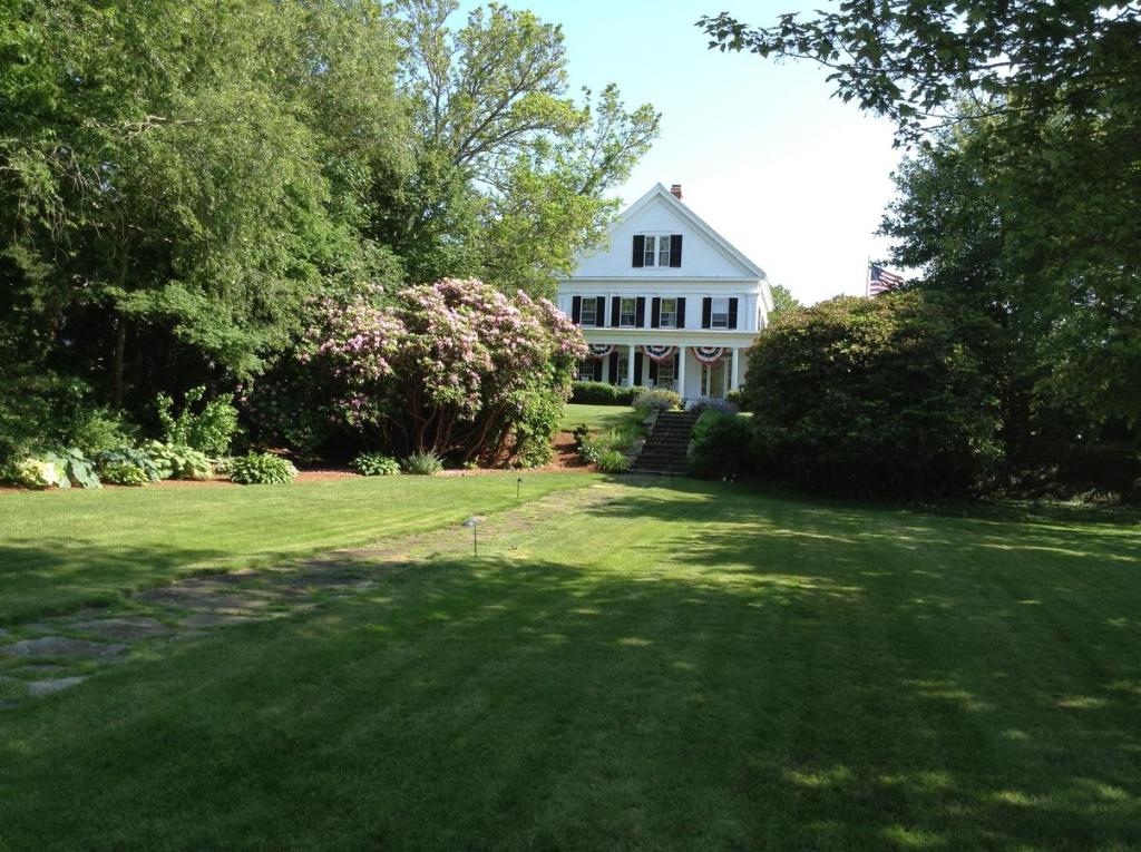 a white house with a large yard with trees at Liberty Hill Inn in Yarmouth