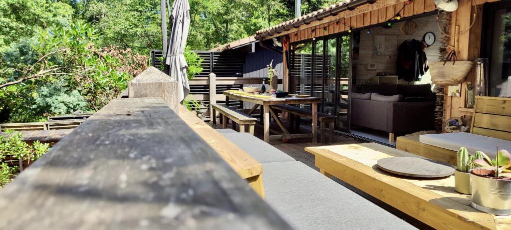 an outdoor patio with a table and a bench at Tres belle maison en bois,dans la Marina, 10pers, au bord de leau in Lacanau