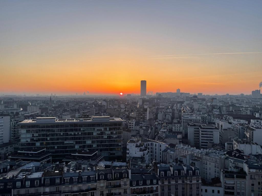a view of a city at sunset at Panoramique vue NEW design proche Tour Eiffel in Paris