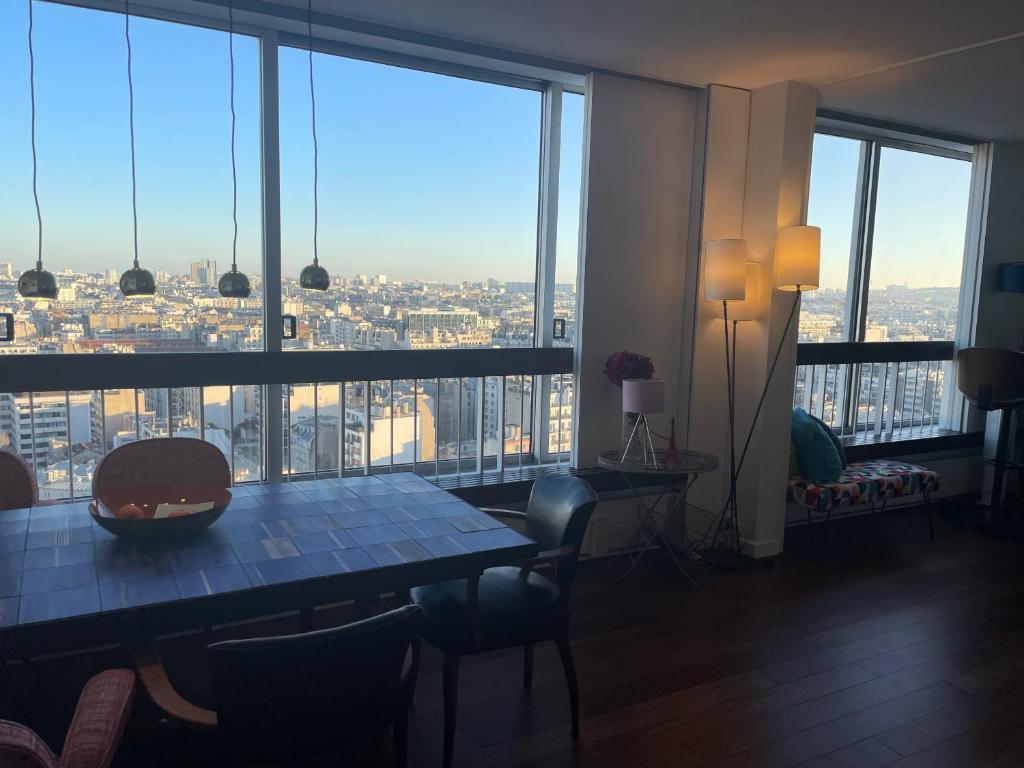 a room with a table and a view of a city at Panoramique vue NEW design proche Tour Eiffel in Paris