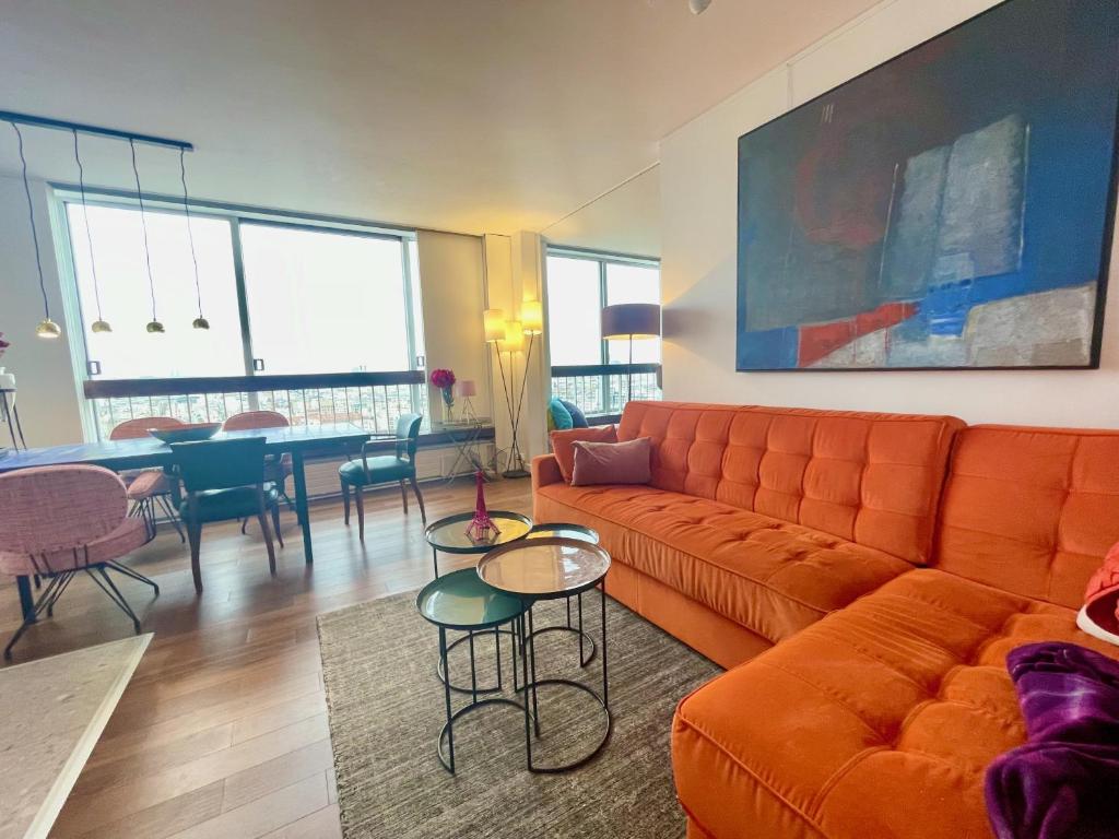 a living room with an orange couch and a table at Panoramique vue NEW design proche Tour Eiffel in Paris