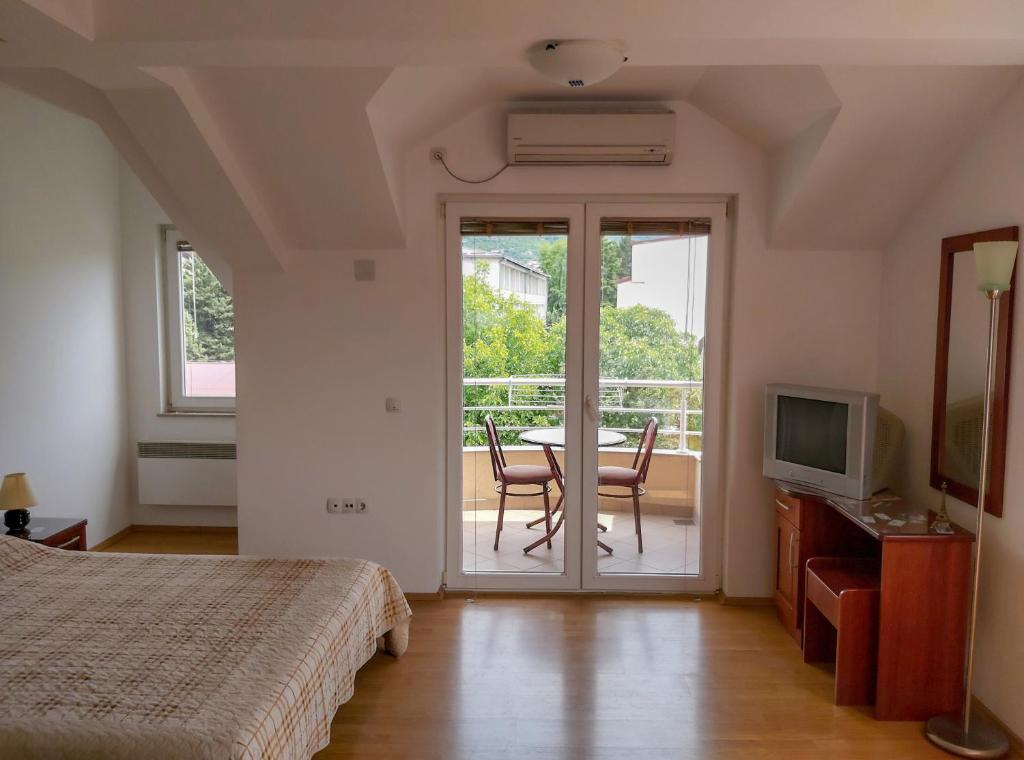 a bedroom with a bed and a table and a balcony at Celus Apartments Ohrid in Ohrid