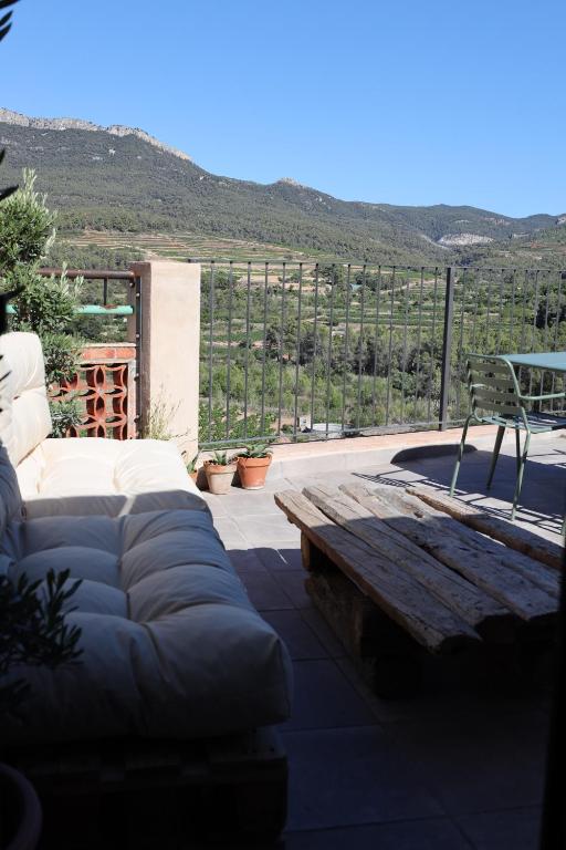 a couch and a bench on a patio with a view at Ático con terraza en Capçanes in Capsanes