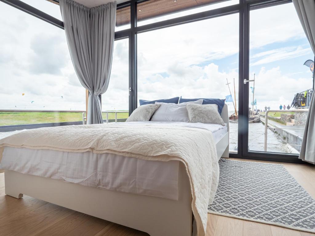 a bedroom with a bed and a large window at Twin Boats - Butterfly in Dreverna