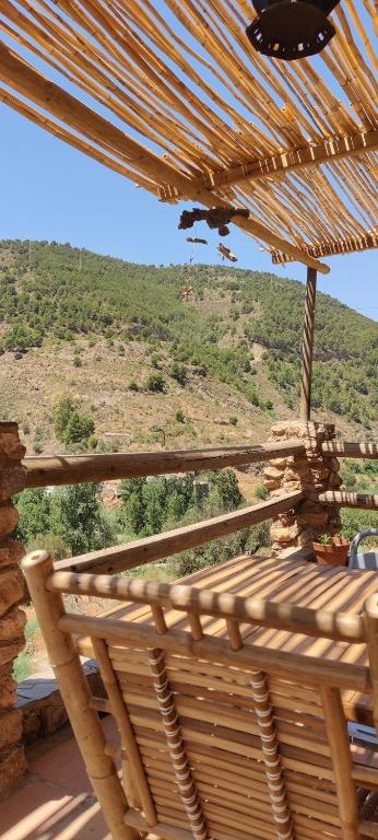 a wooden porch with a view of a mountain at Casa Lola - off grid vakantiehuisje - Puerto Mika in Torviscón