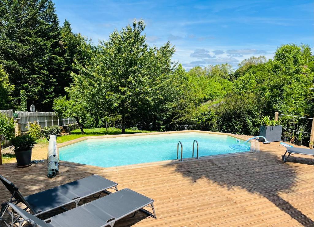 basen z 2 krzesłami i drewniany taras w obiekcie Villa Lila - Sarlat Centre piscine et jacuzzi w mieście Sarlat-la-Canéda