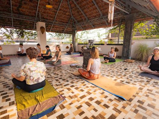 a group of people sitting in a yoga class at La Lune Fort Kochi in Cochin