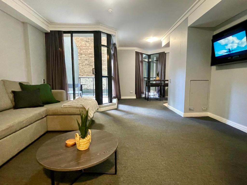 Hotel Sydney City Getaway 1 Bdrm Apt 2 Bathrms Sleeps 4, a living room with a couch and a tv at Sydney City Getaway 1 Bdrm Apt 2 Bathrms Sleeps 4 in Sydney
