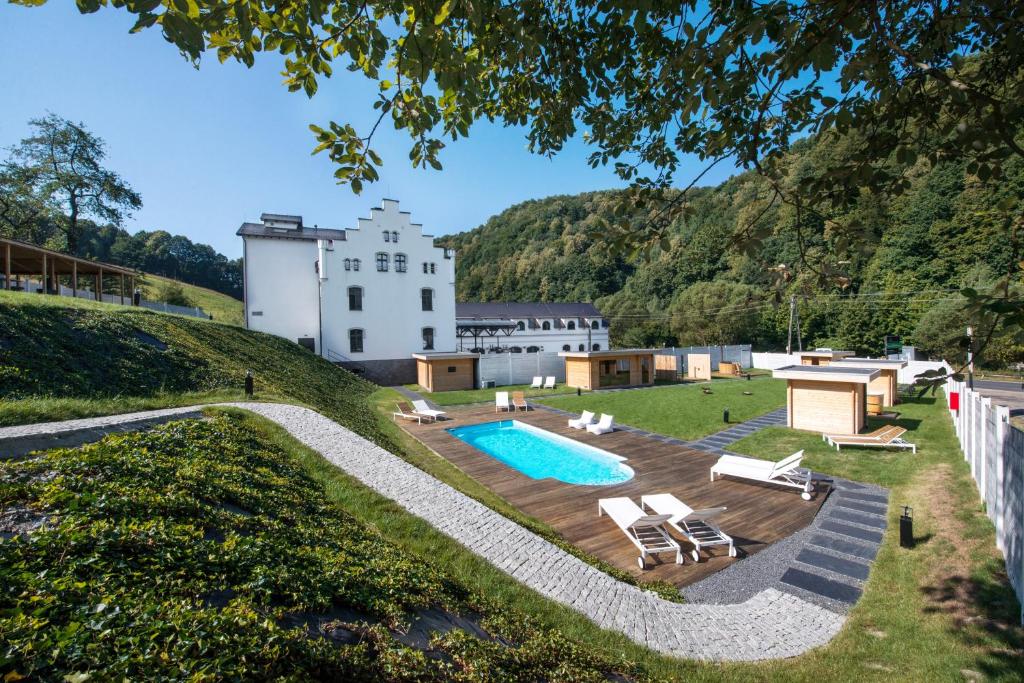 une maison sur une colline avec une piscine dans l'établissement Hotel Pałac Jugowice, à Wałbrzych