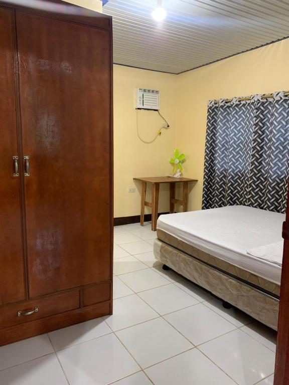 a bedroom with a bed and a wooden cabinet at Tina Homestay in Burgos