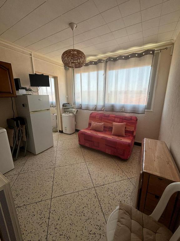 - un salon avec un canapé rouge dans l'établissement L'Arbousier, à Port-la-Nouvelle