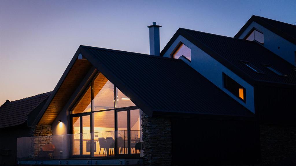 una casa con ventanas de cristal en un lateral en Altfel Bran Chalet 1, en Bran