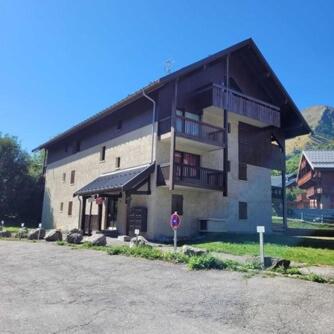 un grand bâtiment avec un balcon au-dessus dans l'établissement Valloire - Appartement au pied des pistes, à Valloire