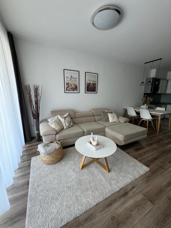 a living room with a couch and a table at Lelle Resort Apartman in Balatonlelle
