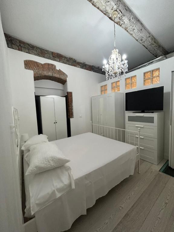 a white bedroom with a bed and a television at Chez Sophie in La Spezia