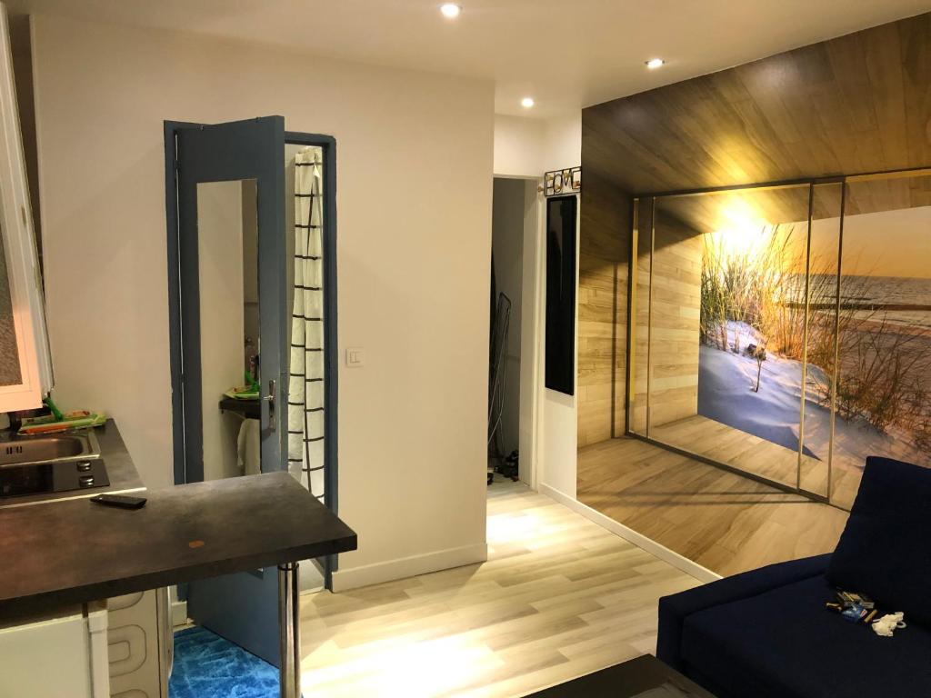 un salon avec une grande porte vitrée avec un tableau sur le mur dans l'établissement Appartement quartier Sainte Marthe, à Paris