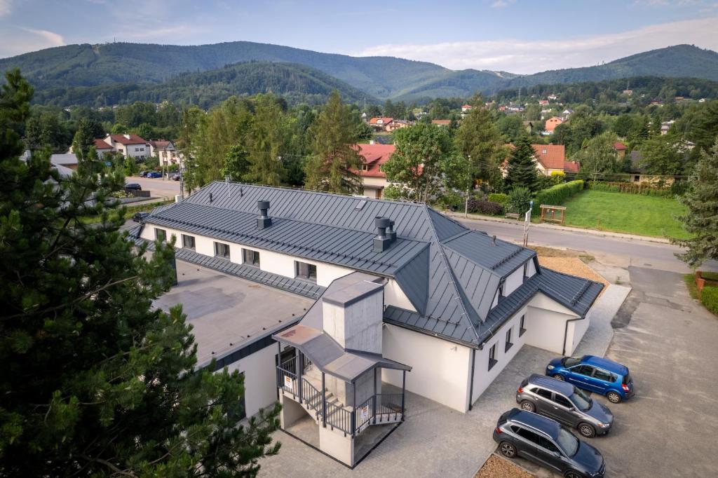 an aerial view of a house with cars parked in a parking lot at Apartamenty Książka do Poduszki - 250 metrów do Bulwarów Wiślanych - Dream Apart in Ustroń