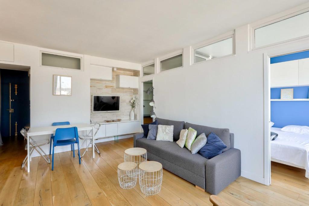 - un salon avec un canapé et une chambre dans l'établissement GuestReady - Charmant Séjour avec Vue Panoramique, à Paris
