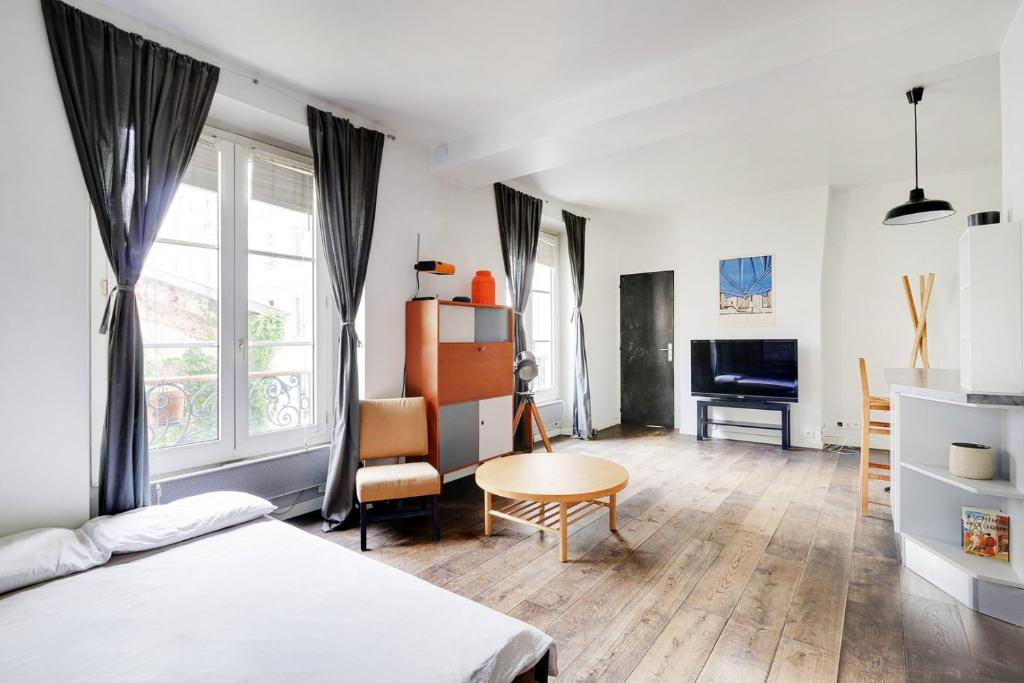 une chambre avec un lit, un bureau et une table dans l'établissement GuestReady - Studio Idéal pour 2 au cœur de Paris, à Paris