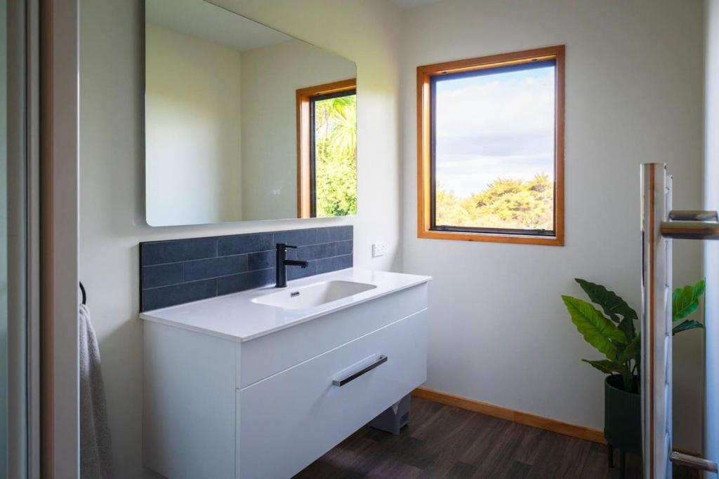 un bagno con un lavandino bianco e uno specchio di Chapman House Auckland ad Auckland