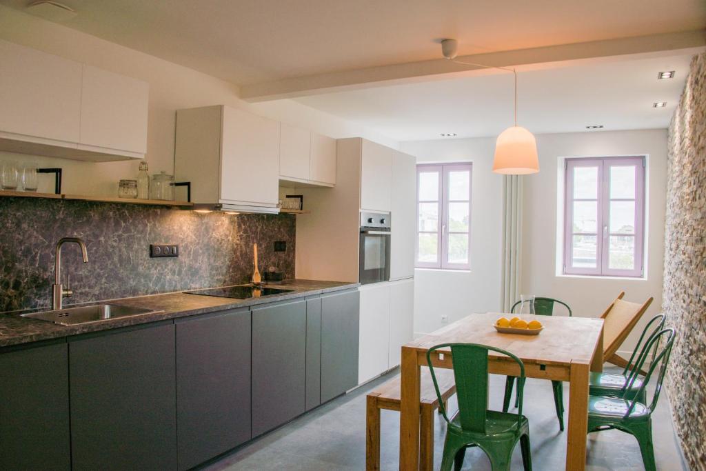 une cuisine avec une table et des chaises ainsi qu'une salle à manger dans l'établissement L'ingénieux de Bazin - proche Place Stanislas, à Nancy