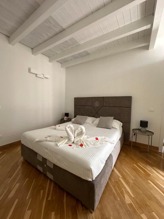 a bedroom with a large bed with a wooden floor at Casa Leoci in Lecce
