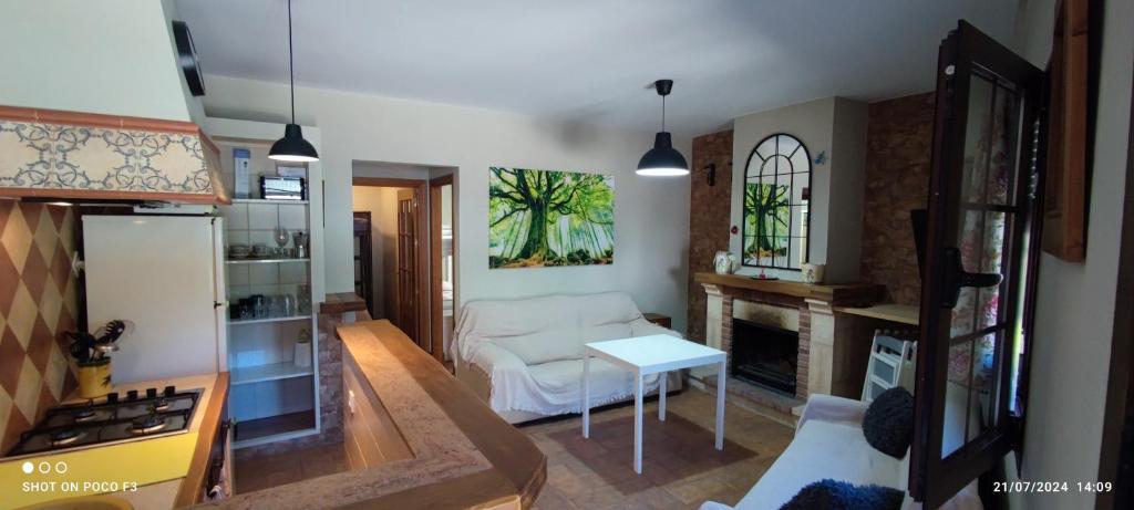 a living room with a white couch and a fireplace at Mi Descanso in El Bosque