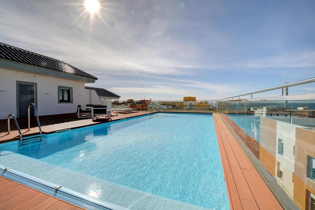 een groot zwembad op het dak van een gebouw bij Central but quiet, pool and WIFI - fibre in Tarifa