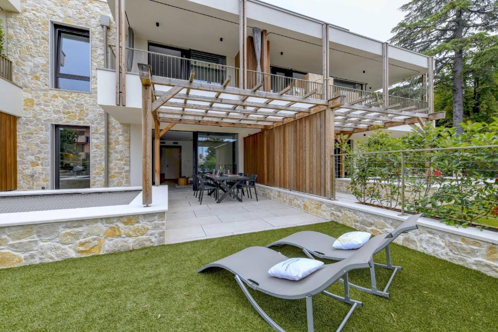 an external view of a house with a patio and lawn at MGH Luxury - Corte Garden Bardolino 34 in Bardolino