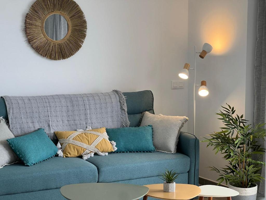 een blauwe bank met kussens in de woonkamer bij Playa Paraiso Apartment in Adeje