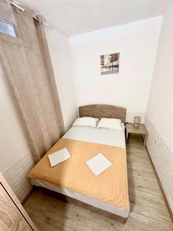 a small bedroom with a bed in a room at Montenegrina Apartment in Budva